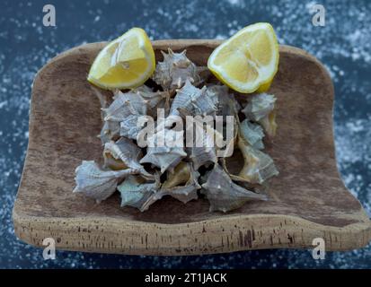 Bolinus brandaris o murici, piatto di boccioli di pesce con limone, lumache di mare bollite, cucina mediterranea Foto Stock