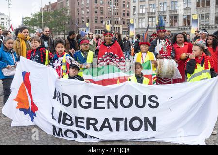 Amsterdam Paesi Bassi. 14 ottobre 2023. Membri di varie comunità indigene tra cui Papua Occidentale, Suriname, messicane e andine si riuniscono sulla diga per una marcia sotto la bandiera del movimento di Liberazione indigena inheemse volkeren, protesta, diaspora, Credit: Imago/Alamy Live News Foto Stock