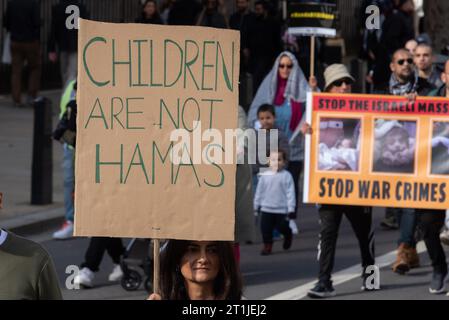 Whitehall, Londra, Regno Unito. 14 ottobre 2023. Una protesta è in corso contro l'escalation dell'azione militare nella Striscia di Gaza mentre il conflitto tra Israele e Hamas continua. Organizzati da gruppi tra cui Palestine Solidarity Campaign e Stop the War Coalition, dal titolo «National Demonstration: March for Palestine» e con inviti a «porre fine alla violenza» e «porre fine all’apartheid», i manifestanti si sono riuniti al di fuori della BBC a Portland Place e stanno marciando verso Whitehall. I bambini non sono un cartello di Hamas Foto Stock