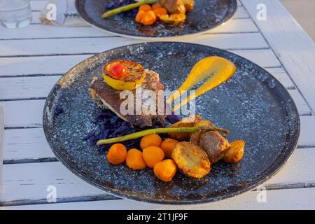 Vista del piatto con pesce fritto e verdure su un tavolo di legno. Concetto di cibo sano. Foto Stock