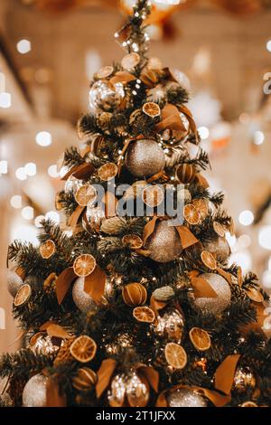 Albero di Natale natalizio decorato con arance secche, coni di pino e mandarini. Dettagli accoglienti. Stagione invernale alla vigilia delle vacanze. Cartolina verticale Foto Stock