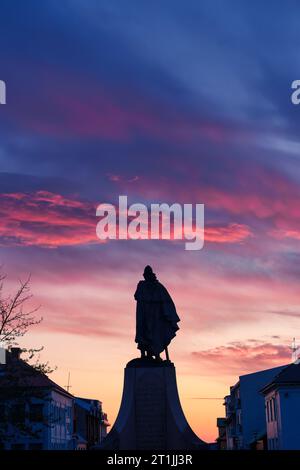 Sagoma dell'imponente statua del monumento di Leif Erikson, un famoso esploratore islandese di fronte alla chiesa principale di Hallgrímskirkja al tramonto Foto Stock