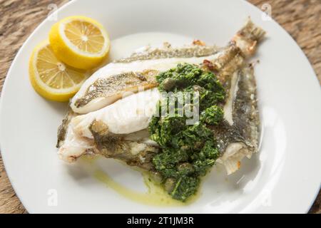 Un John Dory grigliato, Zeus faber, pescato nella Manica servito con salsa alle erbe. Dorset Inghilterra Regno Unito GB Foto Stock