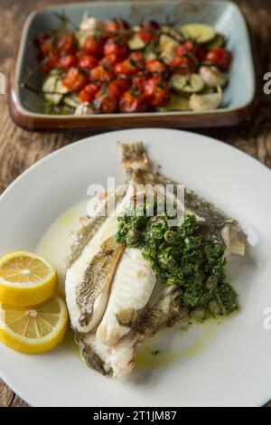 Un John Dory grigliato, Zeus faber, pescato nella Manica servito con salsa alle erbe. Dorset Inghilterra Regno Unito GB Foto Stock