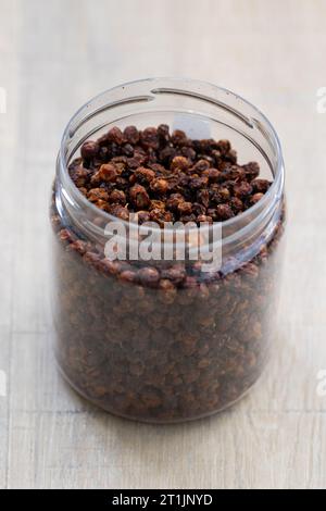 Un ritratto di una pentola o di un vasetto di plastica pieno di tè fresco e sciolto. L'erba è pronta per essere utilizzata in una tazza rilassante della bevanda calda Foto Stock