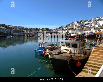 Porto di Brixham, Torbay South Devon, barche ormeggiate al molo e colorati edifici scelti al sole. Foto Stock