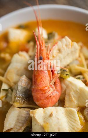 Una zuppa di pesce, aromatizzata allo zafferano, contenente filetti di sogliola di dover, filetti di gurnard e gamberi selvatici catturati. Dorset Inghilterra Regno Unito GB Foto Stock