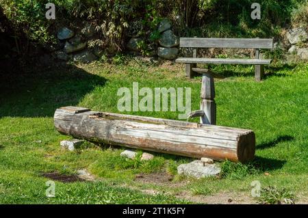 Vasca d'acqua tradizionale in legno, pozzo d'acqua con vaschetta nelle Alpi europee Foto Stock