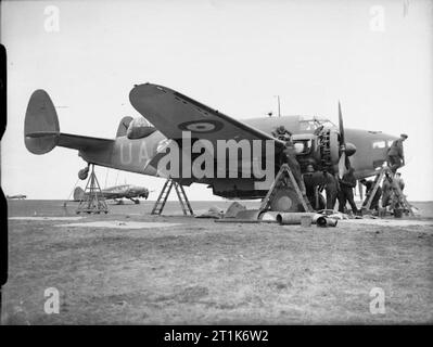 Royal Air Force Coastal Command, 1939-1945. Manutenzione Groundcrew Lockheed Hudson contrassegnare I, N7303 "UA-B', di No.269 Squadron RAF a Wick, Caithness. Il velivolo è stato fissato in una posizione di volo allo scopo di testare il suo avanzamento macchina di cottura-pistole a sparare in botti. Un Avro Anson contrassegnare I, K6244, anche dello squadrone, può essere visto a sinistra. Foto Stock