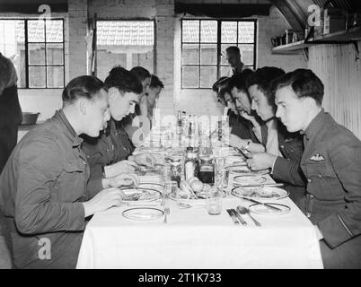 I piloti di n. 19 Squadron RAF mangiare il pranzo in ufficiali' Mess a Fowlmere, il satellite airfield di Duxford nel Cambridgeshire, settembre 1940. Ufficiali di n. 19 Squadron RAF prendere il pranzo in ufficiali' Mess a Manor Farm, Fowlmere, Cambridgeshire. Le condizioni di vita a Fowlmere, un satellite airfield di Duxford, erano molto essenziali, comprendente due Nissen capanne e numerose tende sparsi intorno alla zona da cortile. Foto Stock