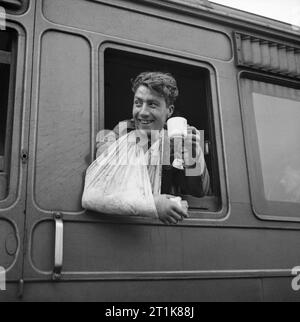 Un soldato ferito, evacuato dalla Normandia, gode di una tazza di tè su un treno ospedale, 7 giugno 1944. Un soldato ferito, evacuato dalla Normandia, gode di una tazza di tè su un treno ospedale, 7 giugno 1944. Foto Stock