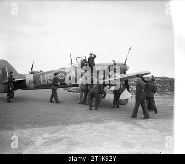 Royal Air Force Fighter Command, 1939-1945. Personale di terra assumere Hawker Typhoon Mark IB, DN374 'US-A', di n. 56 Squadron RAF, al fine di prepararlo per un altro sortie, come pilota ufficiale di volo R Poulter, sgancia da se stesso il cockpit al suo ritorno Matlaske, Cornwall. Foto Stock