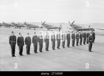 Royal Air Force Fighter Command, 1939-1945. I piloti di n. 310 () Cecoslovacca Squadron RAF, guidati dal loro comandante, Squadron Leader J Hartman, sfilano davanti a loro il Supermarine Spitfire LF Mark IXs all'aeroporto di Praga, al ritorno in patria. Foto Stock