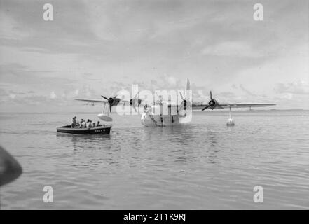 Operazioni della Royal Air Force in Estremo Oriente, 1941-1945 Un tender trasporta l'equipaggio a Short Sunderland Mark III, EJ143'S, del No. 230 Squadron RAF Detachment, ormeggiato nella laguna presso l'atollo di Addu, nelle Isole Maldive. Foto Stock