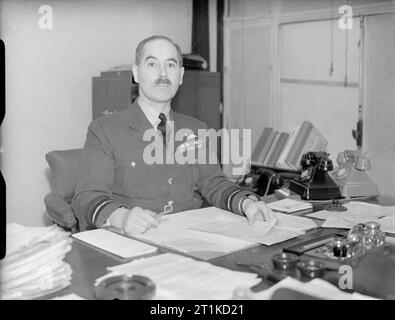 Il Ministero dell'aria, 1939-1945. Il Maresciallo dell'aria A G R Garrod, membro del consiglio di aria per la formazione, alla sua scrivania a Adastral House, Londra. Foto Stock