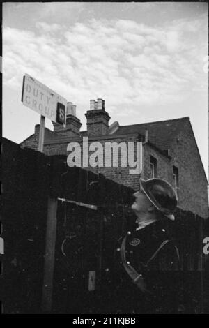 Difesa civile sulla British Home Front, Inghilterra, 1941 un raid aereo precauzioni (ARP) Warden controlla il firewatchers' dovere consiglio di gruppo su una strada (Clifton Road), da qualche parte in Inghilterra. Questa fotografia è stata probabilmente preso in ottobre 1941. Foto Stock