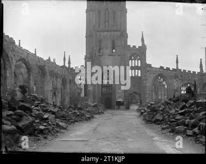 Coventry, la molla 1944- La vita quotidiana di Coventry, Warwickshire, Inghilterra, Regno Unito, 1944 Una vista del guscio scoperchiata di Coventry Cathedral, guardando in giù il corridoio da altare fine verso ovest la torre e la porta. Le macerie e detriti vengono impilati all'interno, con un largo sentiero cancellati tramite verso la porta. Foto Stock