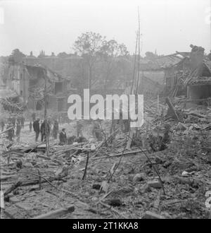 Flying Bomb- V1 danno della bomba a Londra, Inghilterra, Regno Unito, 1944 Difesa Civile soccorritori stand su cumuli di macerie come provano a scavare i sopravvissuti fuori di edifici crollati a seguito di una V1 attacco nella Highland Road e Lunham area di strada di Norwood, London, SE19. In background, semi-distrutto le case può anche essere visto. Foto Stock