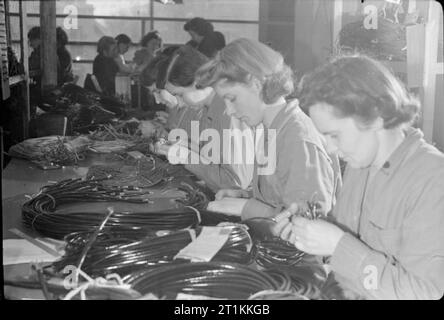 Da Poltrone di bombardieri- Guerra al lavoro Perrings Showroom mobili, Kingston, Surrey, 1943 Part-time donne lavoratori guerra ispezionare i cavi nel dipartimento di ispezione del 'factory' a Perrings Showroom mobili. Essi sono la produzione di apparecchiature elettriche per la Royal Air Force. Foto Stock