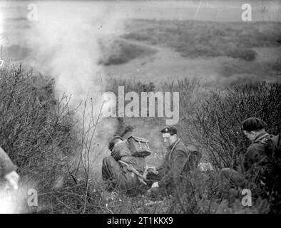 Commandos belga in formazione in Gran Bretagna, 1945 Come parte della loro formazione Commando, da qualche parte in Gran Bretagna, tre soldati belga in carica di malte fire una bomba fumogena prima di un attacco. Foto Stock