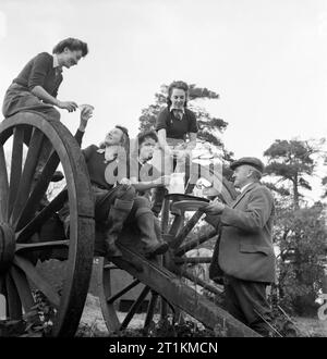 Le ragazze di terra Godetevi una calda tazza di tè dopo una dura giornata di cattura di ratto su Sussex azienda durante il 1942. Le ragazze di terra Eileen Barry, Audrey Willis, Betty lungo e Audrey Prickett Godetevi una calda tazza di tè dopo una dura giornata di cattura di ratto, come parte della loro formazione su Sussex farm. Essi sono qui seduti su grandi cartwheels, mentre l'Agricoltore Giles li porta una brocca del latte fresco da aggiungere alla loro tè. Foto Stock