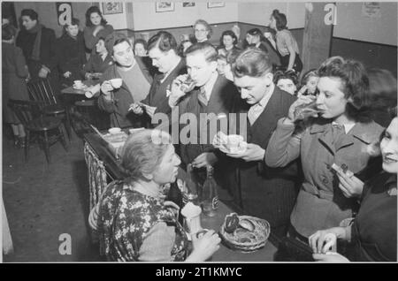 Gli ebrei di Londra in tempo di guerra - il lavoro di circoli giovanili in Stepney, London, 1942 uomini, donne e giovani gustare rinfreschi di tè, la limonata e panini, probabilmente alla Brady insediamento Hanbury Street in Stepney. Foto Stock