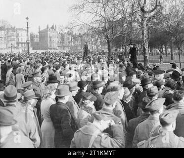 Londra in primavera del 1941- La vita quotidiana a Londra in Inghilterra una grande folla ha raccolto in corrispondenza dell'altoparlante ad angolo per ascoltare due degli altoparlanti in azione sotto gli alberi sul bordo di Hyde Park, Londra. Foto Stock