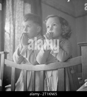 Lussemburghesi in Inghilterra- sfollati nel Surrey, 1942 Cinque anni di Andrea e di tre anni di Jacqueline dicono le loro preghiere prima di accomodarvi a dormire presso la casa in cui hanno la dimora, da qualche parte nel Surrey. La didascalia originale afferma che essi sono memori dei loro nonni, ancora in Lussemburgo, nelle loro preghiere, come ogni notte. Foto Stock