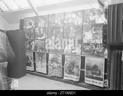 Ministero delle informazioni mostre durante la Seconda Guerra Mondiale, Basingstoke, Hampshire, Inghilterra, Regno Unito, 1942 Un display di poster e fotografie relative alla industria bellica, parte di un ministero di informazioni mostra tenutasi a Latham memorizza, Basingstoke. Foto Stock