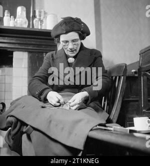 Il MEND e far fare- sartoria in classi di Londra, 1943 La signora K Holmes fare un cappotto per uno dei suoi tre bambini a farlo e a ricucire la classe attualmente sta frequentando. Questa classe è tenuto presso l' ufficio di Kennington succursale del partito laburista. Lei sembra essere la cucitura di una tasca a mano. Foto Stock