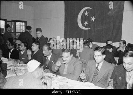 I musulmani in Gran Bretagna- Eid Ul Fitr celebrazioni, 1941 Una vista degli uomini godendo di una festa a seguito della Eid ul Fitr cerimonia presso la East London moschea. Foto Stock
