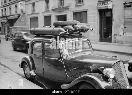 Traffico parigino, Primavera 1945- La vita quotidiana a Parigi, Francia, 1945 Una vista di una strada Parigina, mostrando una vettura che è stata convertita per funzionare a gas, piuttosto che di benzina. Ci sono quattro cilindri a gas attaccata al tetto della vettura, e un piccolo tubo corre downs il lato della vettura e sotto il cofano. Foto Stock