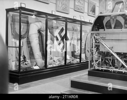 La riapertura del Imperial War Museum di Londra dopo la Seconda Guerra Mondiale, 1946 Un display dei vari elementi descritti dal segno sulla parte superiore dell'armadio come 'nemico reliquie", presso l'Imperial War Museum di Londra. Incluso in questo caso di vetro sono un paracadute pack, un gommone e una bandiera nazista, tutti dei quali era stato recentemente acquisita e sono ora in corso di visualizzazione pubblica per la prima volta. Foto Stock