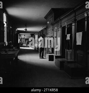 Royal Hospital Chelsea- La vita di tutti i giorni con il Chelsea pensionati, Londra, Inghilterra, Regno Unito, 1945 Una vista generale di una parte dell'interno del Royal Hospital Chelsea, che mostra uno dei 200 piedi lungo 'lungo pupilli'. Lungo il lato destro della foto può essere visto le cuccette o armadi in cui i pensionati vive. Quando progettate da Wren, gli ormeggi misurato sei piedi quadrati. Nel centro è uno dei campi che vengono utilizzati per la cottura. Foto Stock