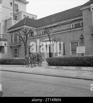 Servizi Club- il lavoro delle donne del volontariato a Chester House, Clarendon Place, Londra, Inghilterra, 1943 Mrs Bolton, deliberando il soprintendente della WVS-eseguire servizi Club, (centro), chat ai membri dell'ATS e WAAF sui gradini del Club a Chester House su Clarendon posto. La bacheca legge 'Chester Club House per altri ranghi delle donne del servizi, Clarendon Place, Paddington, W2. Non residenziale. Aperto tutti i giorni (anche la Domenica) dalle 10.00 alle 22.00". Foto Stock