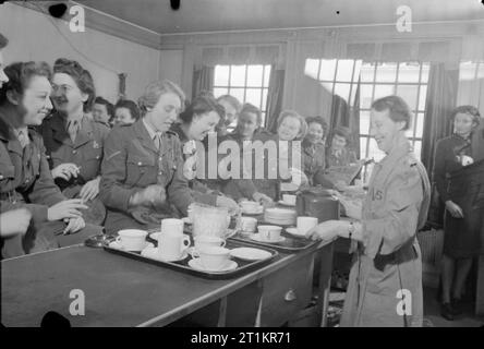 Servizi Club- il lavoro delle donne del volontariato a Chester House, Clarendon Place, Londra, Inghilterra, 1943 Mrs M Hunt del WVS versa il tè per un gruppo di ATS e WAAF nel self-service caffetteria presso i servizi Club a Chester House. Al centro della fotografia, in mezzo alla folla di accodamento servicewomen presso il contatore, è il signor Bolton, la recitazione soprintendente del club. Foto Stock