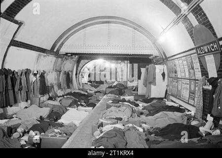 La metropolitana di Londra come Air Raid Shelter, Londra, Inghilterra, 1940 rifugiati accolti da incursioni aeree linea la piattaforma e le vie at Aldwych La stazione della metropolitana di Londra. Una fila di cappotti può essere visto appeso alla parete. Foto Stock