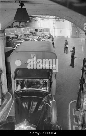 La ricostruzione di un "incidente'- Difesa Civile Formazione in Fulham, Londra, 1942 una trafficata scena dentro il Fulham ambulanza stazione come difesa civile lavoratori diretti driver ambulanza al di fuori del magazzino a Seagrave Road. Quattro ambulanze sono inviati all'incidente a trattare con barella casi. Foto Stock