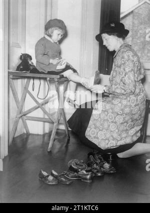 Il lavoro dei cittadini Advice Bureau, Eldon House, Croydon, Inghilterra, 1940 Una giovane ragazza è equipaggiato per le nuove scarpe da una femmina di attività di volontariato presso i cittadini " ufficio di consulenza a Croydon. Foto Stock