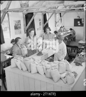 Essi hanno anche lotta che solo il supporto e attendere- part-time lavoro Guerra nel Surrey, Inghilterra, 1943 all'Chilingfold/Chiddingfold depot, il supervisore di testa la signora Harner pesa sacchetti di rivetti dopo che essi sono stati ordinati per il part-time lavoratore di guerra in diversi workshop' nell'area locale. Foto Stock