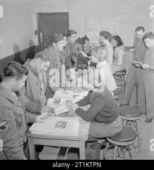 US Army University, Shrivenham (Inghilterra, Regno Unito, 1945 donne inglesi informare gli studenti all'US Army University, Shrivenham su varie questioni. Tra il GIs cerca consigli sono Caporale Wilfred Hoenninger, in primo piano, essendo mostrato un opuscolo sulla città di Cambridge da Meredydd Saunders-Davies. Il prossimo in linea (allontanandosi dalla telecamera) è il Capitano Edward K Austin, che vuole andare in Scozia. Secondo la didascalia originale, 'Dark dai capelli Diana Phipps appollaiato su uno sgabello in background è un nipote della Duchessa di Gloucester'. In primo piano un altro GI guarda a una pila di copie del 'Sh Foto Stock