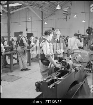 Formazione di Wakefield prigione e Camp- La vita di tutti i giorni in un carcere britannico, Wakefield, Yorkshire, Inghilterra, 1944 nelle opere di ingegneria a Wakefield Prigione di formazione, i detenuti sono stati addestrati in un nuovo commercio come parte delle loro azioni di riabilitazione e di preparazione per il loro ritorno alla società. In primo piano, uno dei quattro membri del personale del carcere spiega un punto a uno dei detenuti. Foto Stock