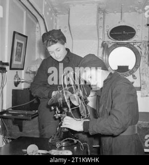 Le donne il Royal Naval Service con la Fleet Air Arm, Scozia, 1943 Manutenzione Wrens ora intraprendere le riparazioni elettriche come parte del loro dovere. Qui, due membri del MEND WRNS un ventilatore elettrico in uno degli ufficiali della marina militare cabine a bordo di una nave per la formazione. Foto Stock