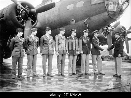 Il colonnello Curtis LeMay si congratula ufficialmente con un equipaggio di bombardieri del 306th Bomb Group di fronte al loro B-17 Flying Fortress. Passato come censurato il 2 giugno 1943. Foto Stock