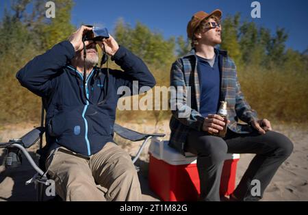 Bluff, Stati Uniti. 14 ottobre 2023. Tim (L) e Simon Viavant osservano la luna che ricopre il sole durante un'eclissi solare anulare "Ring of Fire" nei pressi di Bluff, Utah, sabato 14 ottobre 2023. Foto di Bob strong/UPI credito: UPI/Alamy Live News Foto Stock