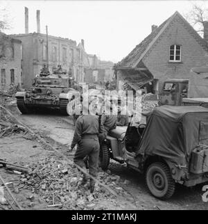 L'Esercito Britannico nel nord-ovest d'Europa 1944-45 una cometa serbatoio e jeep della XI divisione corazzata in un devastato città tedesca, 30 marzo 1945. Foto Stock