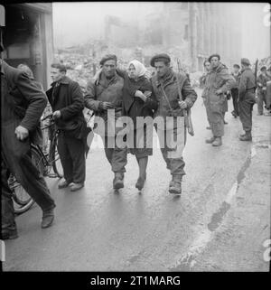 L'Esercito Britannico nel nord-ovest d'Europa 1944-45 liberato russo lavoratori slave di essere salvato da una cantina dopo che era stato impostato sul fuoco da un poliziotto tedesco, Osnabruck, 7 aprile 1945. Foto Stock