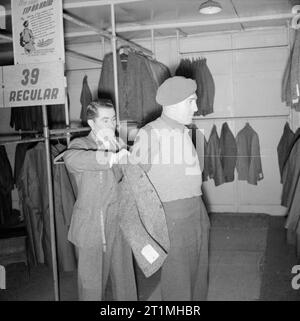 La smobilitazione dell'Esercito britannico quattro milionesimo soldato britannico per essere smobilitati, Rifleman John Neale, di anni 31, del re Royal Rifle Corps, cerca su una camicia alla smobilitazione grande magazzino di abbigliamento all'Olympia di Londra. Neale, di Hounslow, Middlesex, servita come un ufficiale è batman prima di smobilitazione. Foto Stock