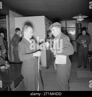 La smobilitazione dell'Esercito britannico quattro milionesimo soldato britannico per essere smobilitati, Rifleman John Neale, di anni 31, del re Royal Rifle Corps, arriva alla smobilitazione grande magazzino di abbigliamento a Olympia, Londra dove si è misurato per una tuta demob. Neale, di Hounslow, Middlesex, servita come un ufficiale è batman prima di smobilitazione. Foto Stock