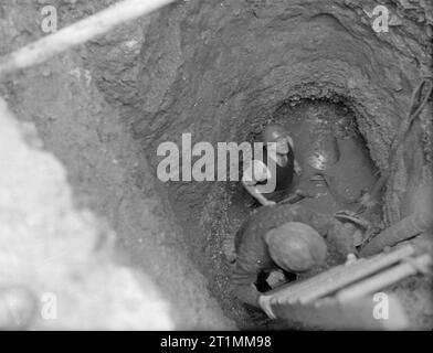 Smaltimento di 1000 Kg bomba tedesca. 11 e 12 gennaio 1943, Devonport. I membri di The Bomb Squad smaltimento discendente nel foro per avviare i lavori per la rimozione della bomba, che è la posa di 18 ft al di sotto della terra. Foto Stock